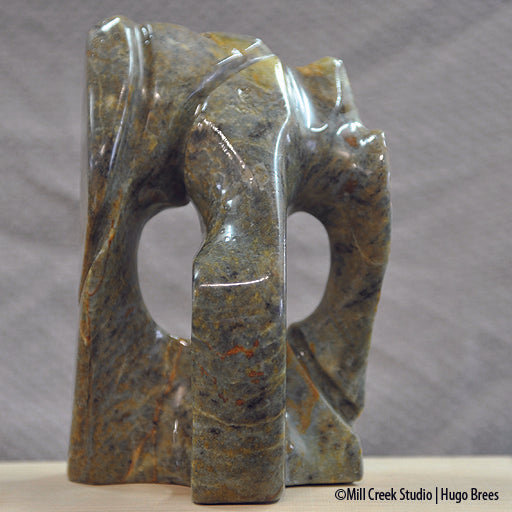 Brazilian Soapstone abstract sculpture in a medley of greens, golds, copper and black colours.