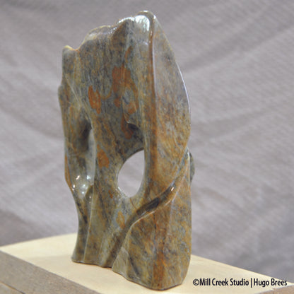 Brazilian Soapstone abstract sculpture in a medley of greens, golds, copper and black colours.