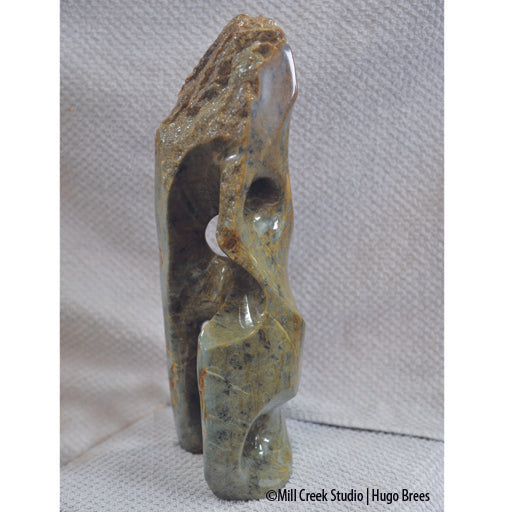 Upright Brazilian Soapstone Sculpture with mid-greens, copper and black mottling. Smooth and natural roughness to finish.