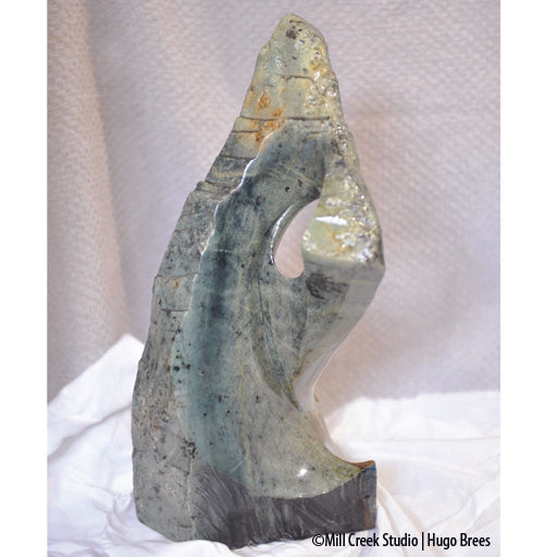 This blue-green Brazilian Soapstone with copper enhancements is shaped to arouse your curiosity.