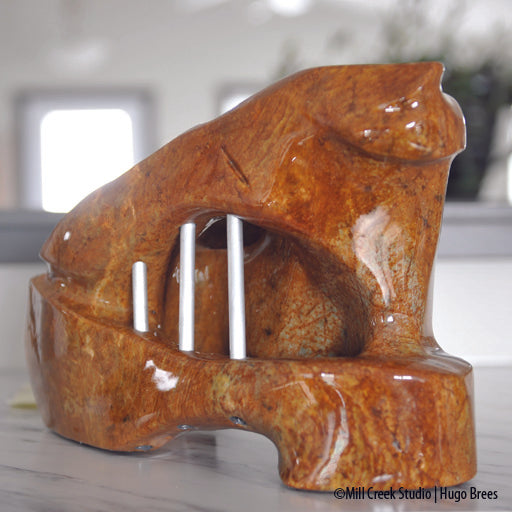 A shock of copper hued Brazilian Soapstone, the sculpture depicts the need for freedom from its sculpted form.A shock of copper hued Brazilian Soapstone, the sculpture depicts the need for freedom from its captured form.