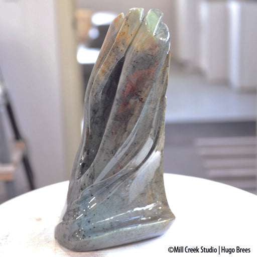 This abstract Brazilian Soapstone sculpture evokes a peaceful flow of colour on the smooth surfaces and a deviation to natural stone on the reverse.