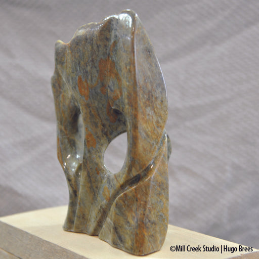 Brazilian Soapstone abstract sculpture in a medley of greens, golds, copper and black colours.