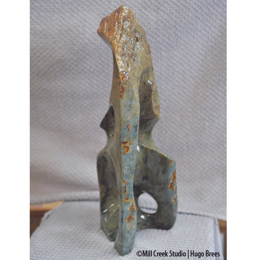 Upright Brazilian Soapstone Sculpture with mid-greens, copper and black mottling. Smooth and natural roughness to finish.