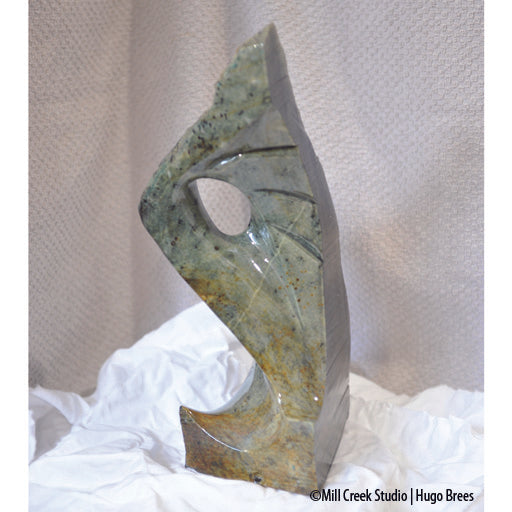 This blue-green Brazilian Soapstone with copper enhancements is shaped to arouse your curiosity.