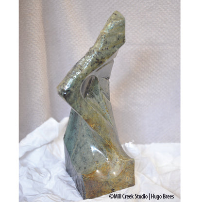 This blue-green Brazilian Soapstone with copper enhancements is shaped to arouse your curiosity.